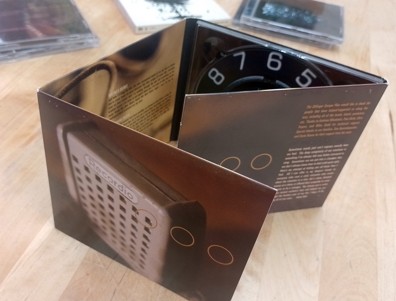 CD copy of Calculating Infinity by The Dillinger Escape Plan in a digipack standing up, showing some of the artwork on the inside