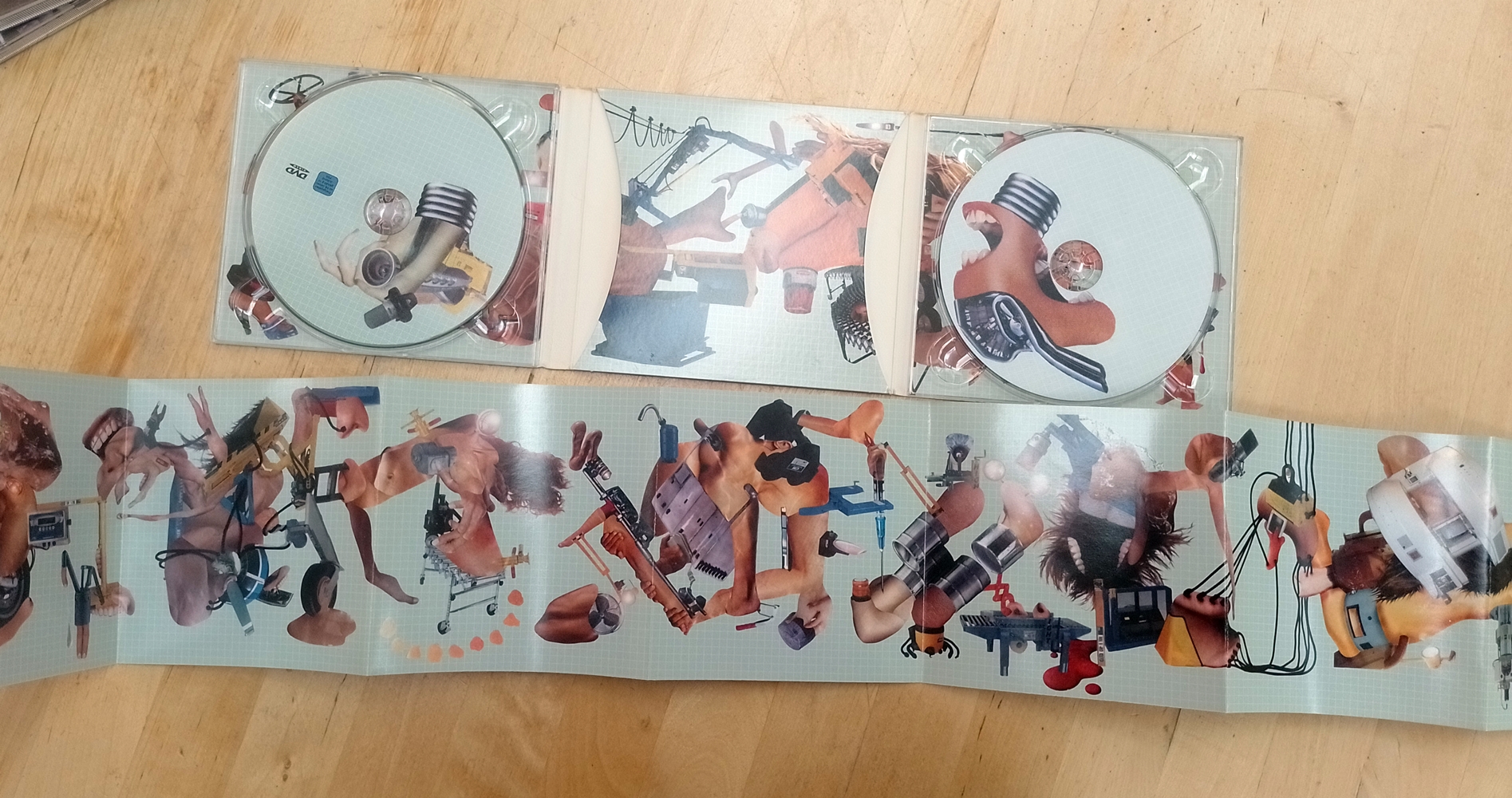 CD + DVD copy of Miss Machine by The Dillinger Escape Plan, digipack opened up and laid out flat on the table with the booklet folded open, showing the full artwork